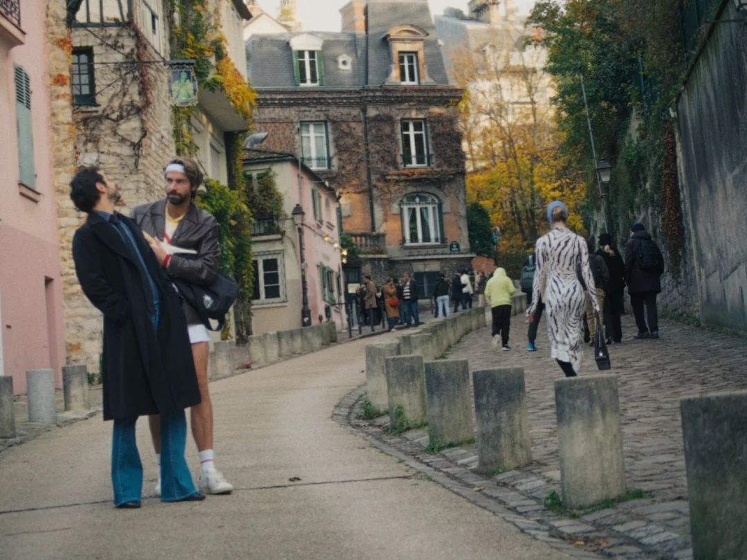 Deux hommes marchent dans une ruelle pavée de Montmartre en automne.