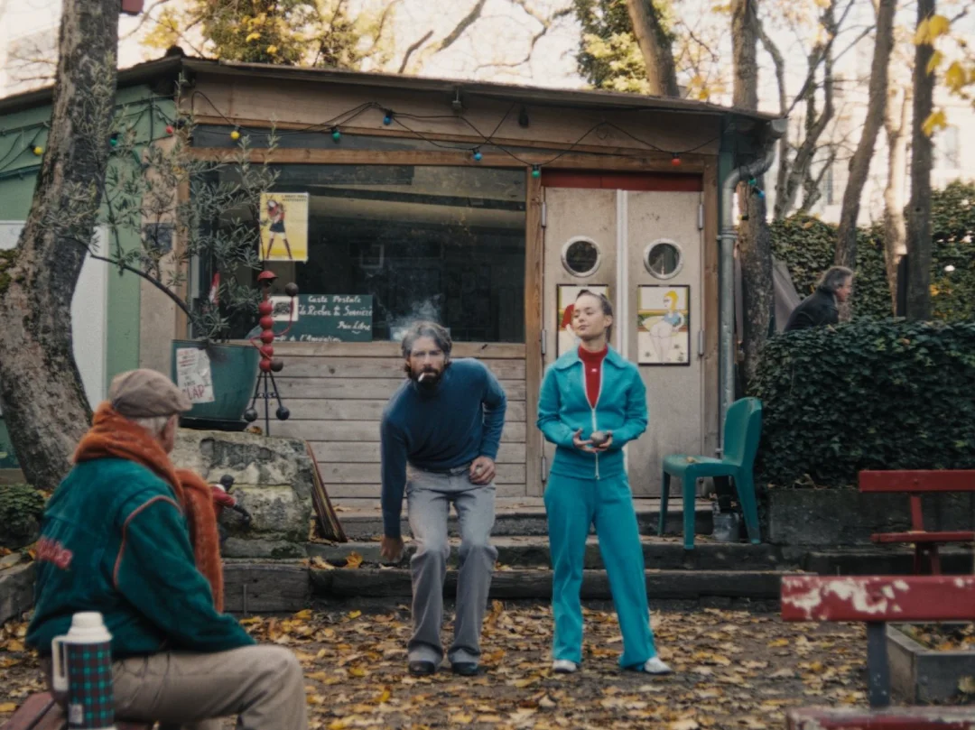 Trois hommes devant une cabane de jardin, en automne.
